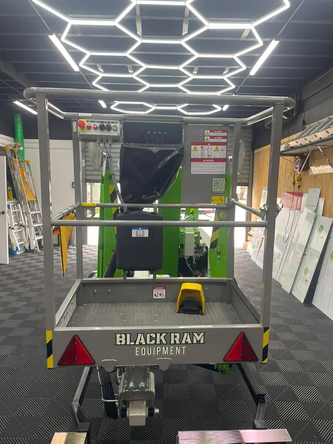 Black Ram boom lift displayed in showroom under hexagon lighting