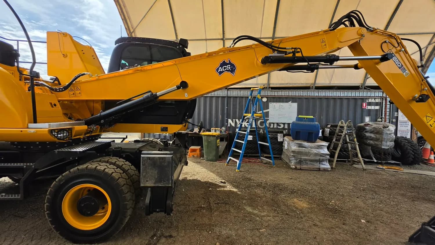Yellow wheeled loader/crane in signage workshop, pre-wrap