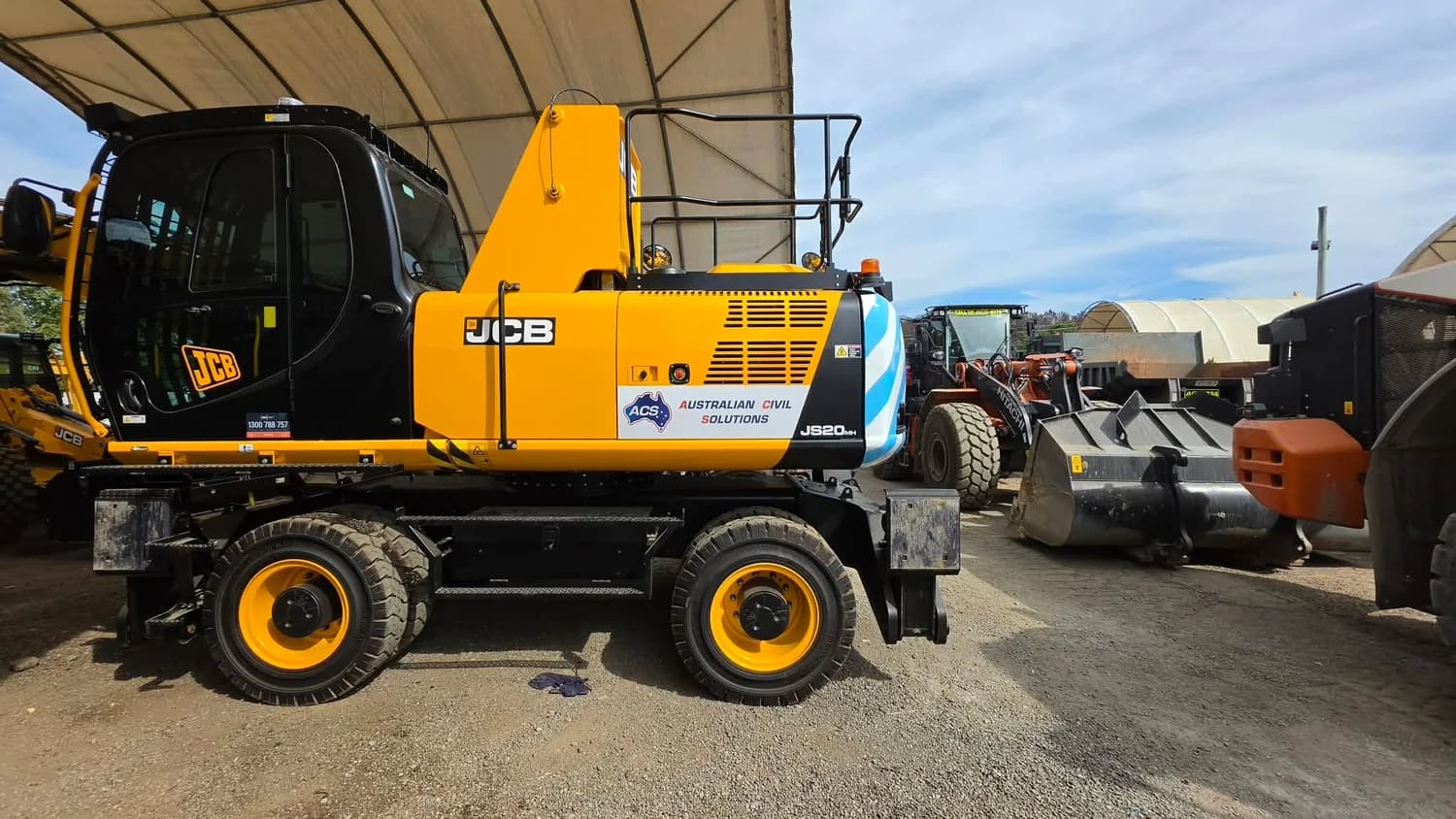 Yellow JCB wheeled excavator in workshop