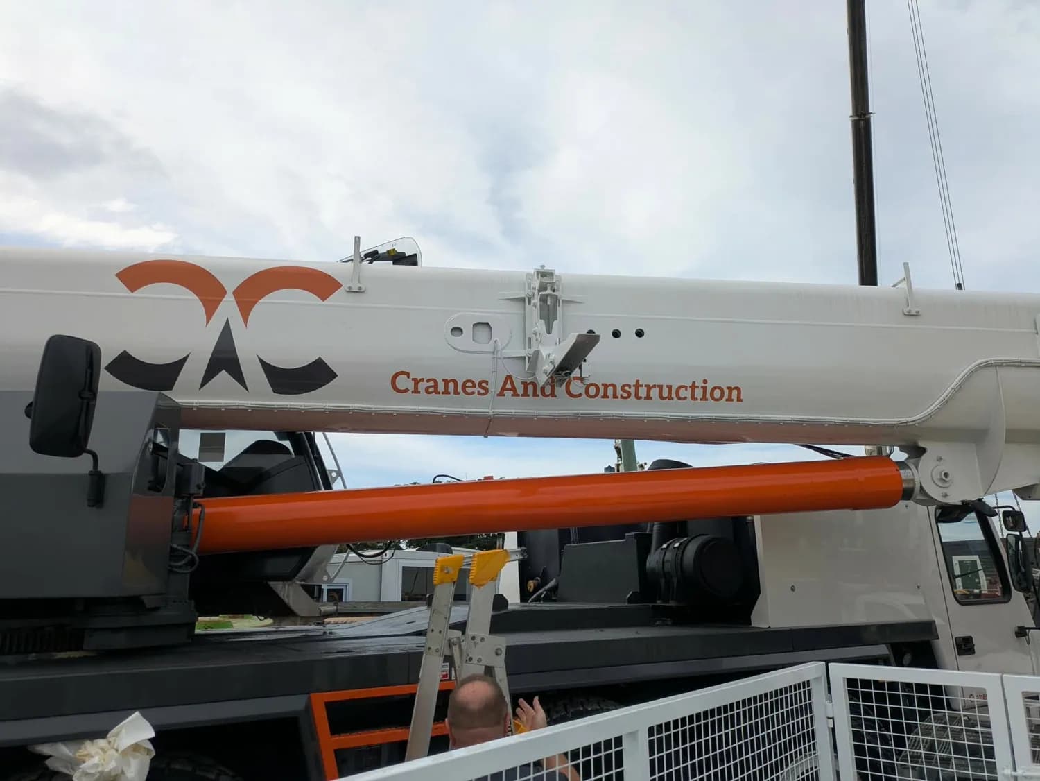 Cranes And Construction mobile crane with orange logo, outdoors