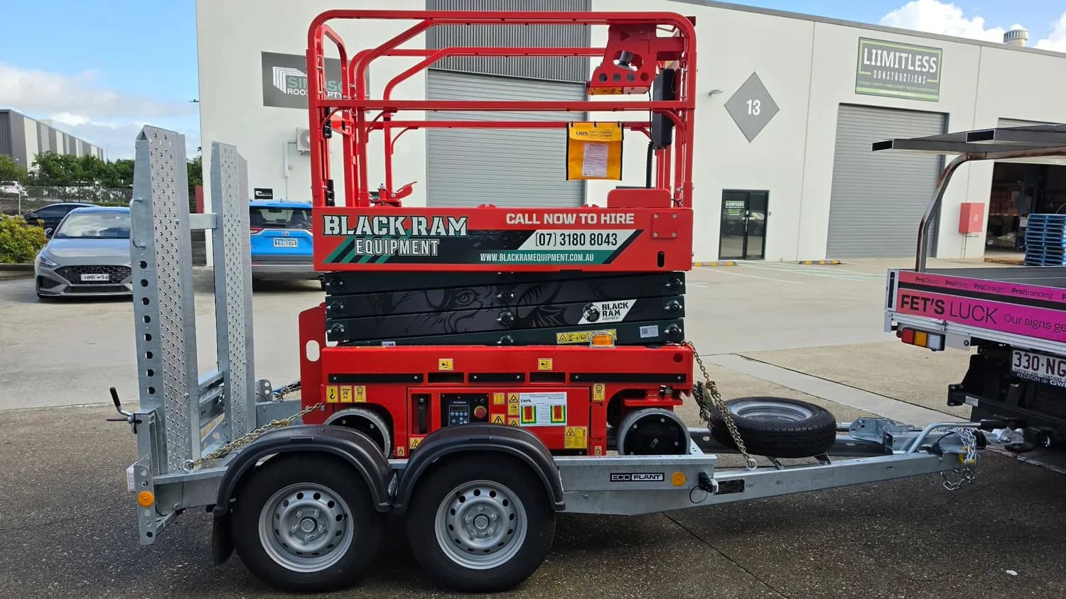 Black Ram Equipment red scissor lift on trailer