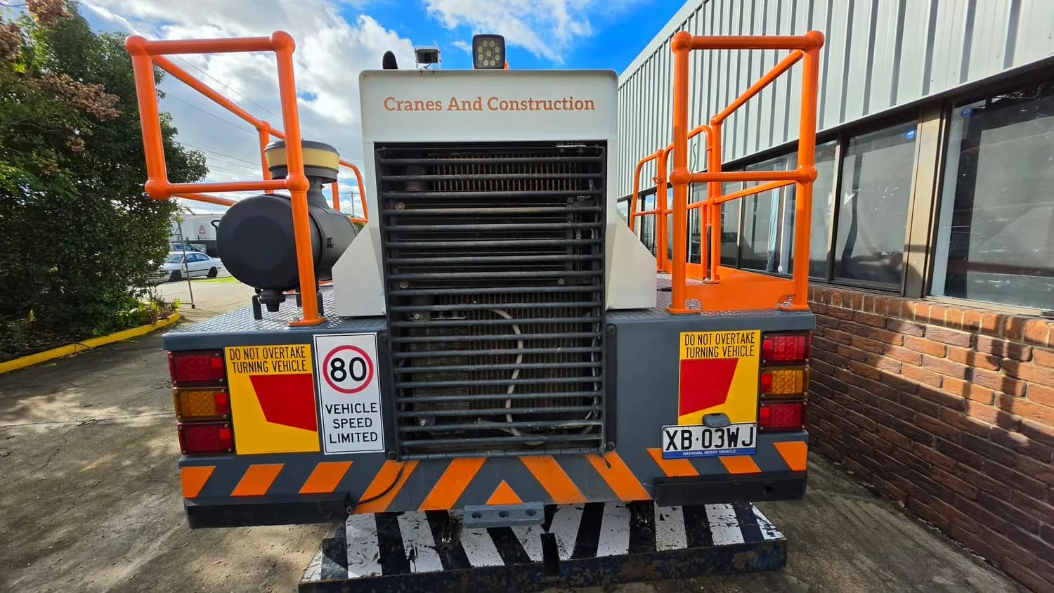 Mobile crane rear with hazard markings and speed sign