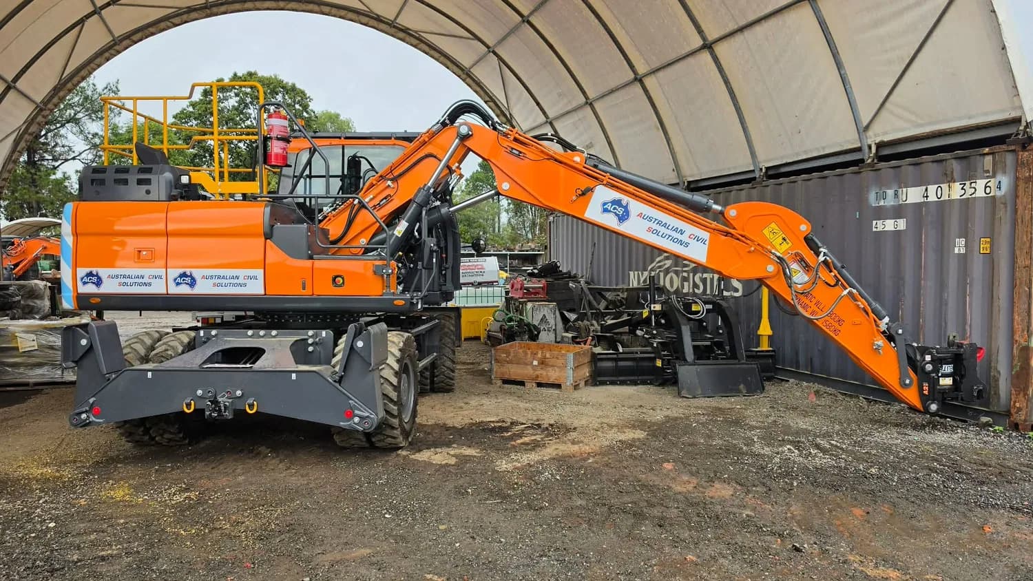 Australian Civil Solutions orange excavator full machine in shed