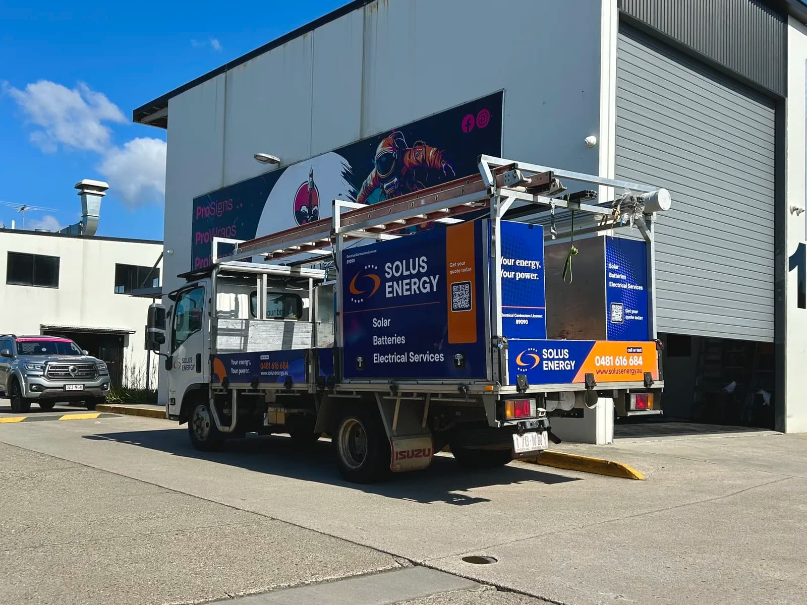 Solus Energy Isuzu truck wrap, rear three-quarter view