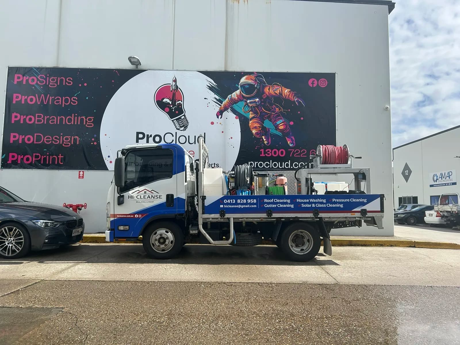 Hi-Cleanse Isuzu flatbed truck, ProCloud mural behind
