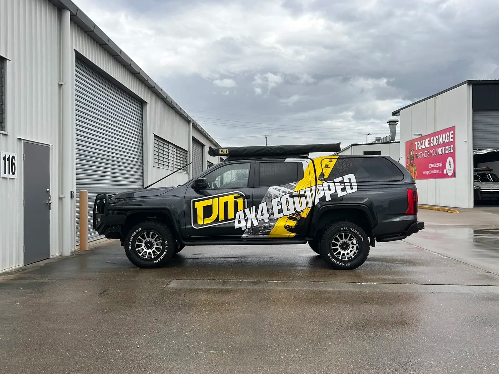 TJM Triton side profile, Tradie Signage backdrop