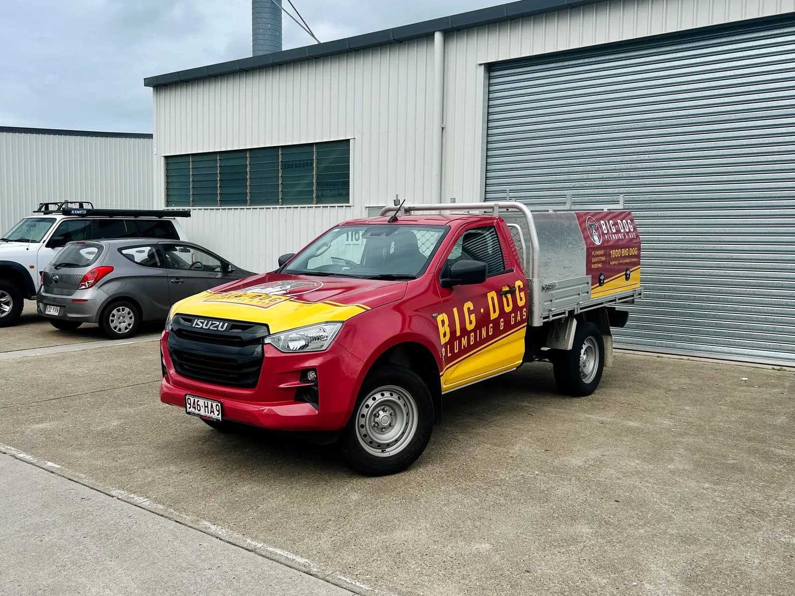 Big Dog Plumbing & Gas Isuzu D-Max single cab, red and yellow tray wrap, front three-quarter
