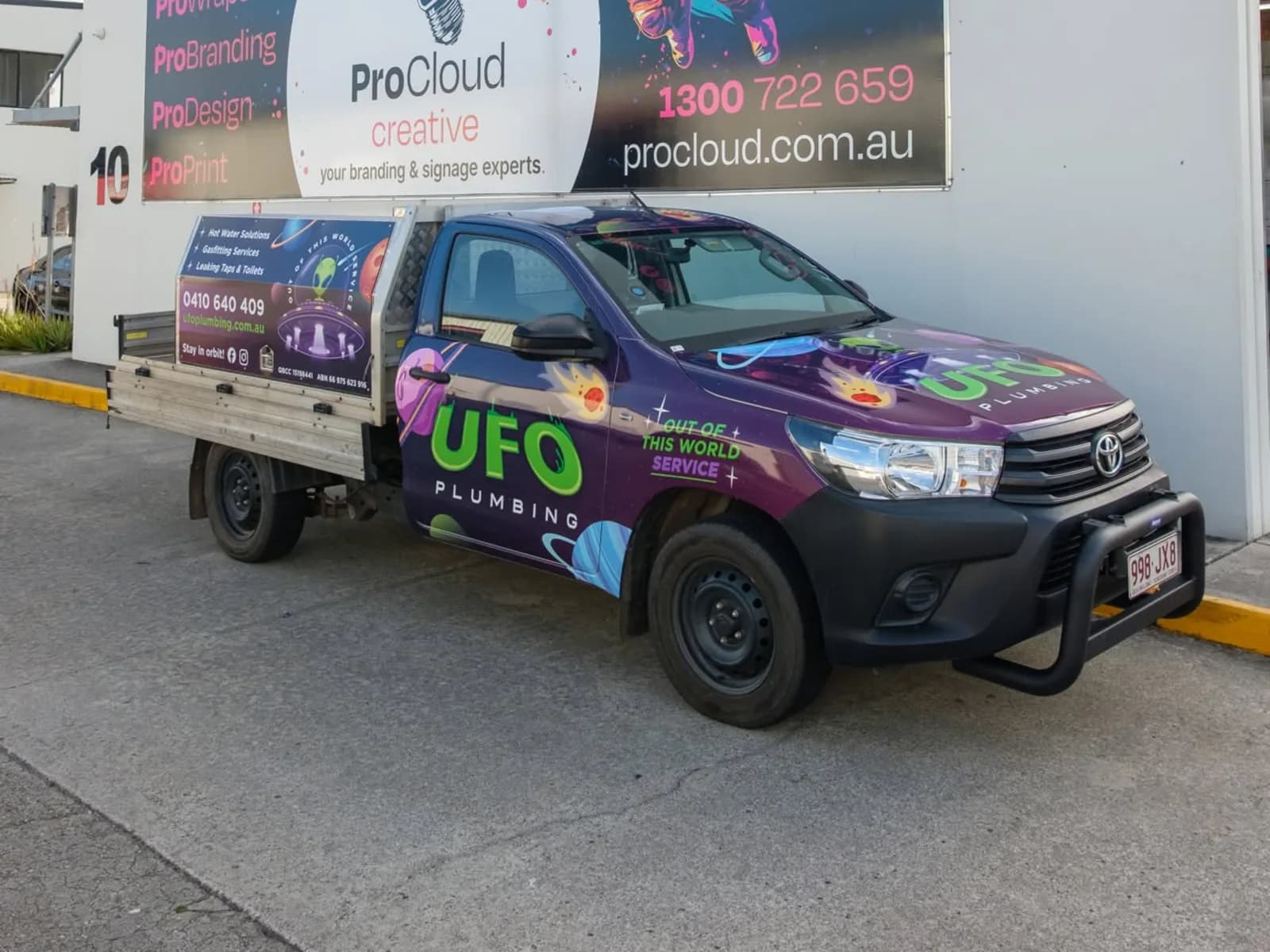 UFO Plumbing Hilux single cab tray, space-themed wrap outside the ProCloud workshop