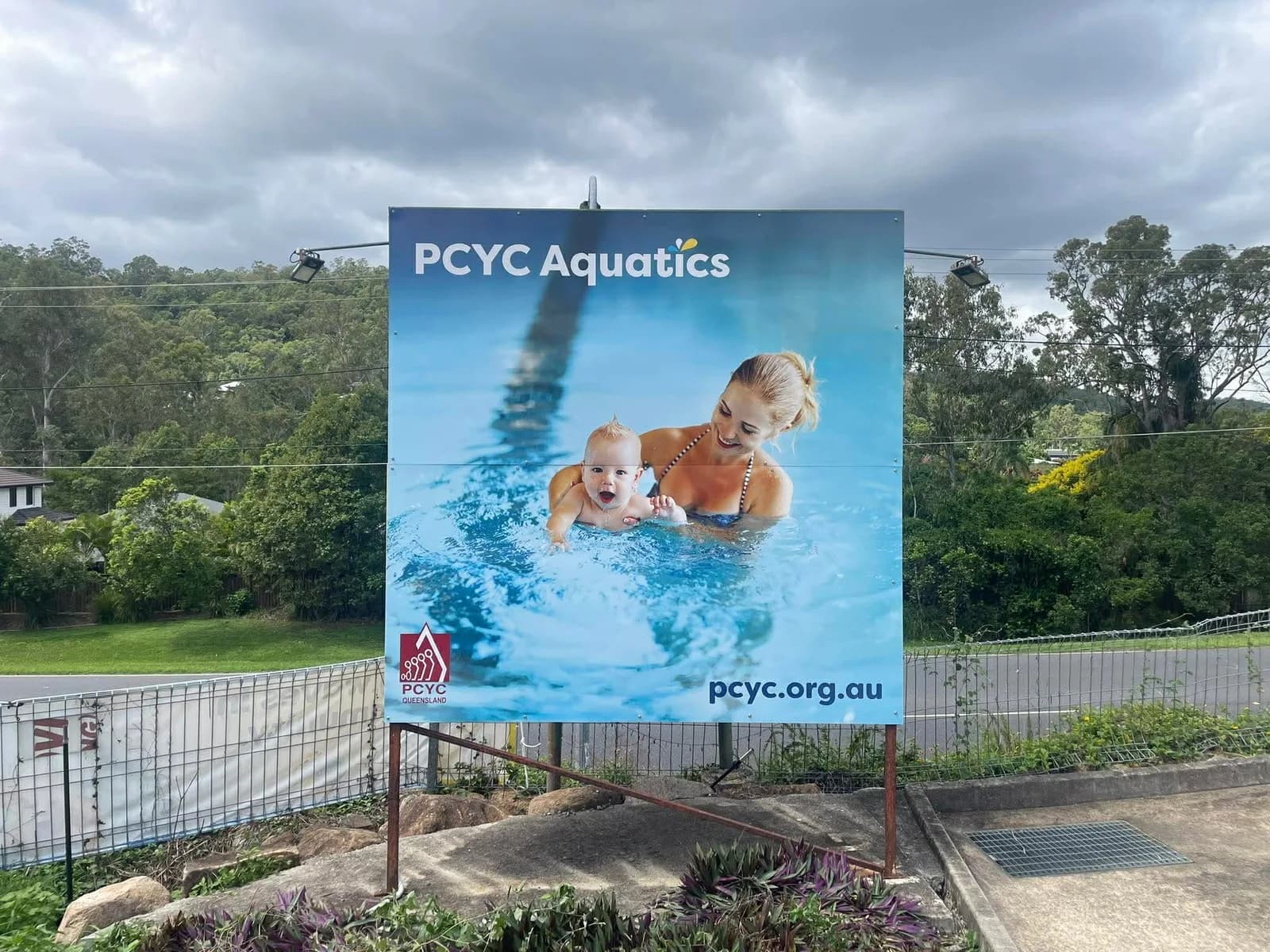 PCYC Aquatics printed panel sign in a garden bed