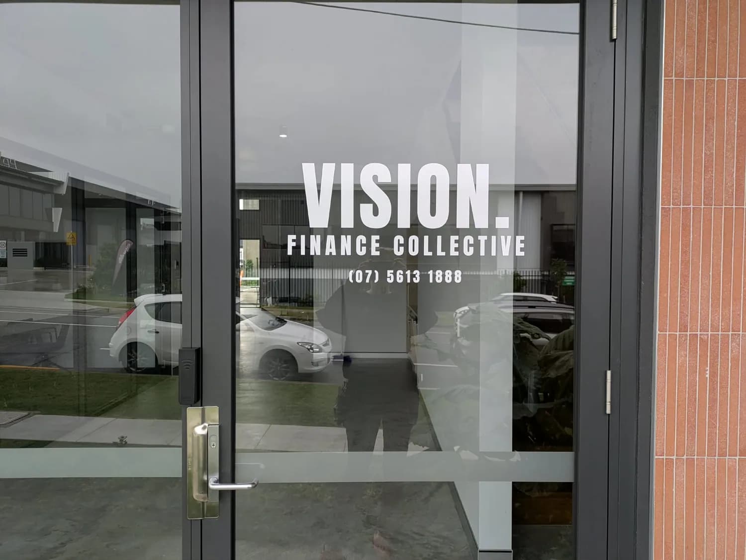 Vision Finance Collective white cut graphics on glass entry door